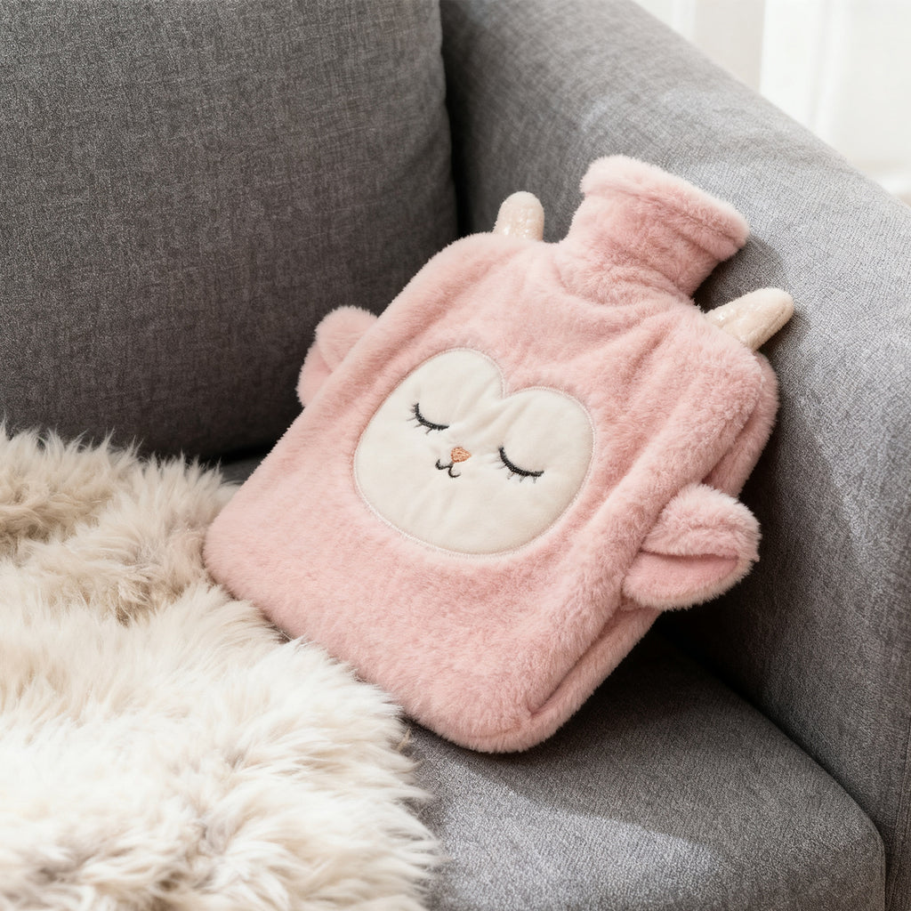 Plush lamb hot water bottle resting on a gray sofa
